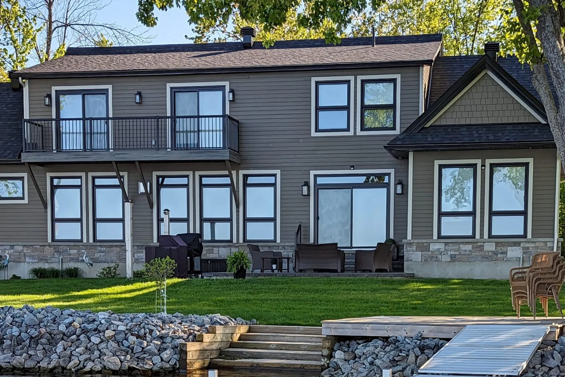 Modern stone-veneer Ottawa home with custom paver patio and natural stone steps by ALM Construction & Landscaping